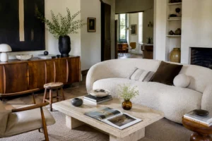 Canapés courbes, tables en travertin, buffets en noyer et fauteuils sculpturaux. Les meubles tendance que les décorateurs privilégient en 2026.